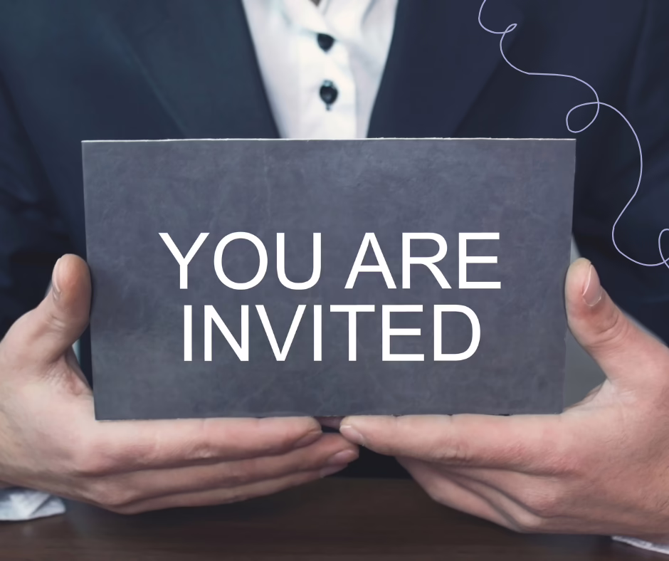 A man holding a slate gray sign that reads "You Are Invited"